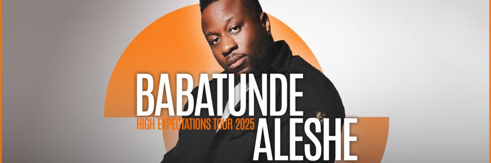Babatunde Aleshe looking at camera with serious expression and his arms crossed in front of him